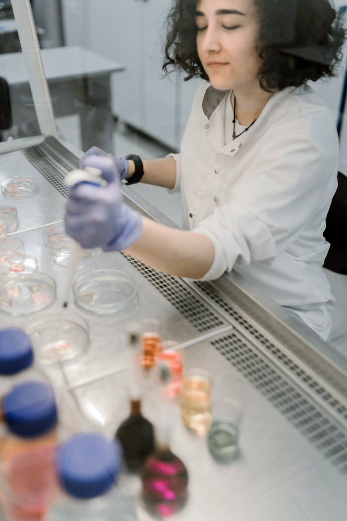 our-experience A woman scientist in a lab, conducting experiments with petri dishes.